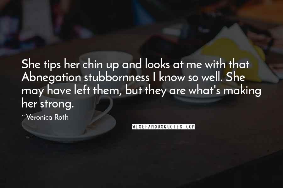 Veronica Roth quotes: She tips her chin up and looks at me with that Abnegation stubbornness I know so well. She may have left them, but they are what's making her strong.