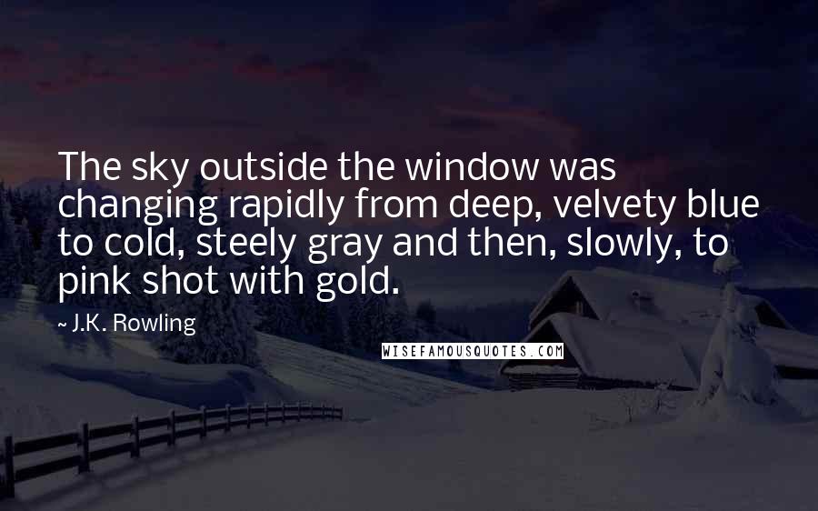 J.K. Rowling Quotes: The sky outside the window was changing rapidly from deep, velvety blue to cold, steely gray and then, slowly, to pink shot with gold.