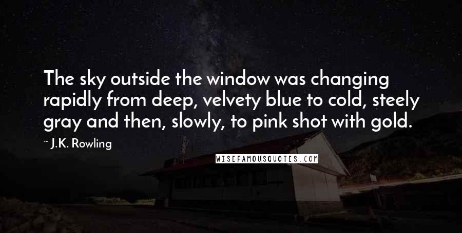 J.K. Rowling Quotes: The sky outside the window was changing rapidly from deep, velvety blue to cold, steely gray and then, slowly, to pink shot with gold.