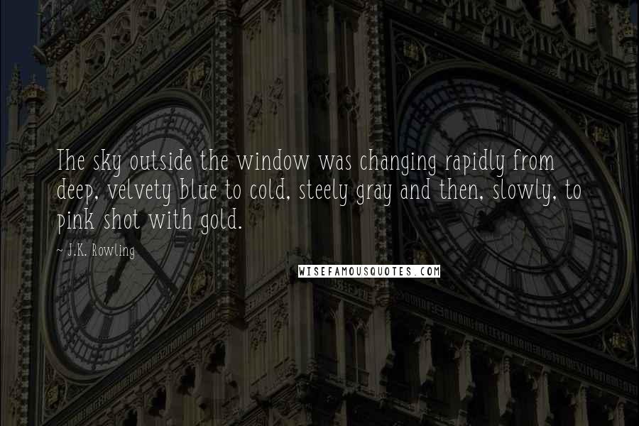 J.K. Rowling Quotes: The sky outside the window was changing rapidly from deep, velvety blue to cold, steely gray and then, slowly, to pink shot with gold.