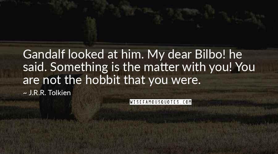 J.R.R. Tolkien Quotes: Gandalf looked at him. My dear Bilbo! he said. Something is the matter with you! You are not the hobbit that you were.