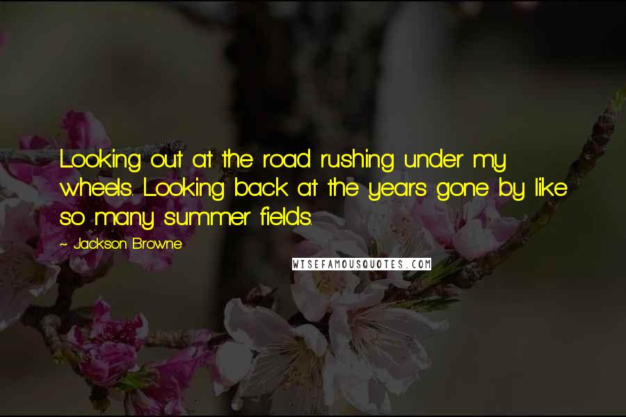 Jackson Browne Quotes: Looking out at the road rushing under my wheels. Looking back at the years gone by like so many summer fields.