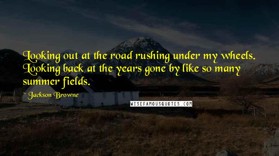 Jackson Browne Quotes: Looking out at the road rushing under my wheels. Looking back at the years gone by like so many summer fields.