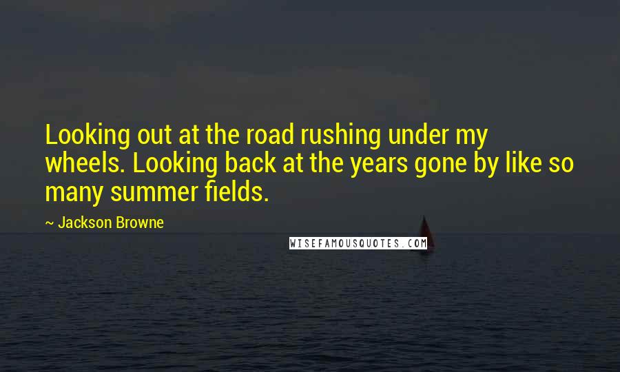 Jackson Browne Quotes: Looking out at the road rushing under my wheels. Looking back at the years gone by like so many summer fields.