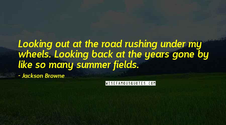 Jackson Browne Quotes: Looking out at the road rushing under my wheels. Looking back at the years gone by like so many summer fields.