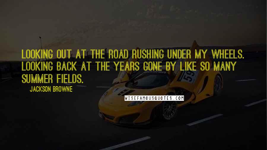 Jackson Browne Quotes: Looking out at the road rushing under my wheels. Looking back at the years gone by like so many summer fields.