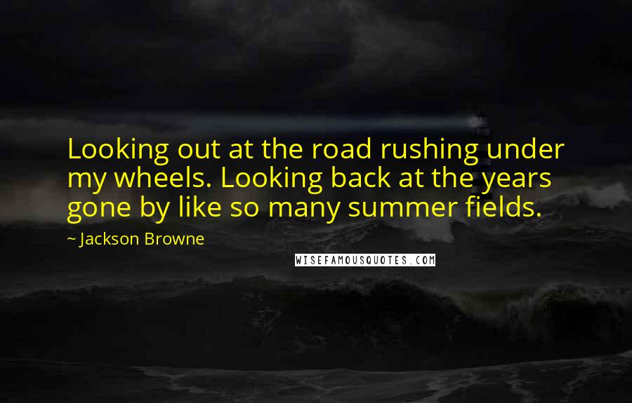 Jackson Browne Quotes: Looking out at the road rushing under my wheels. Looking back at the years gone by like so many summer fields.