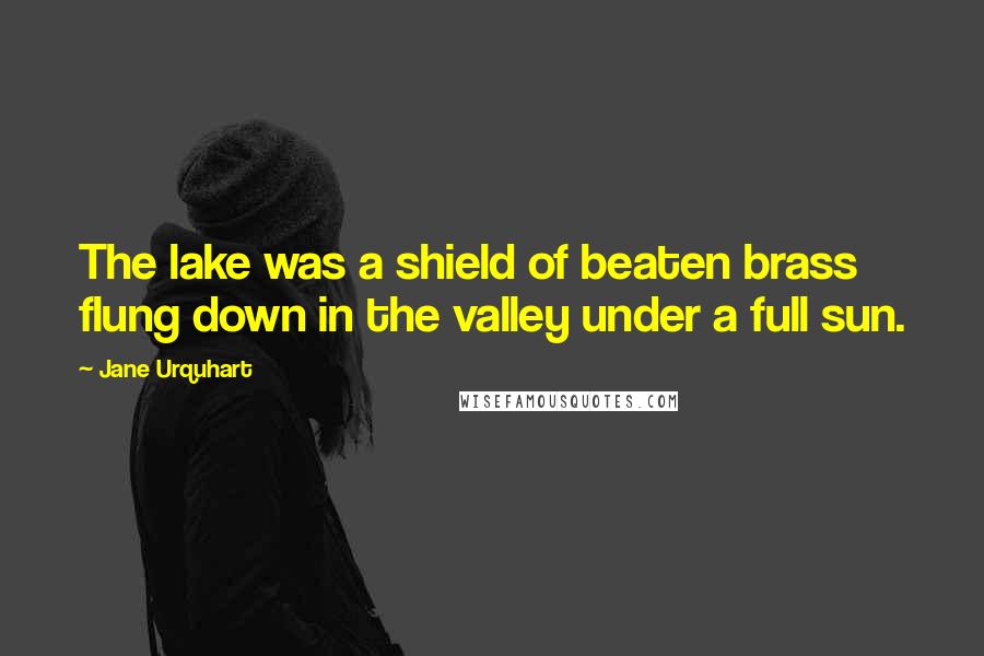 Jane Urquhart Quotes: The lake was a shield of beaten brass flung down in the valley under a full sun.