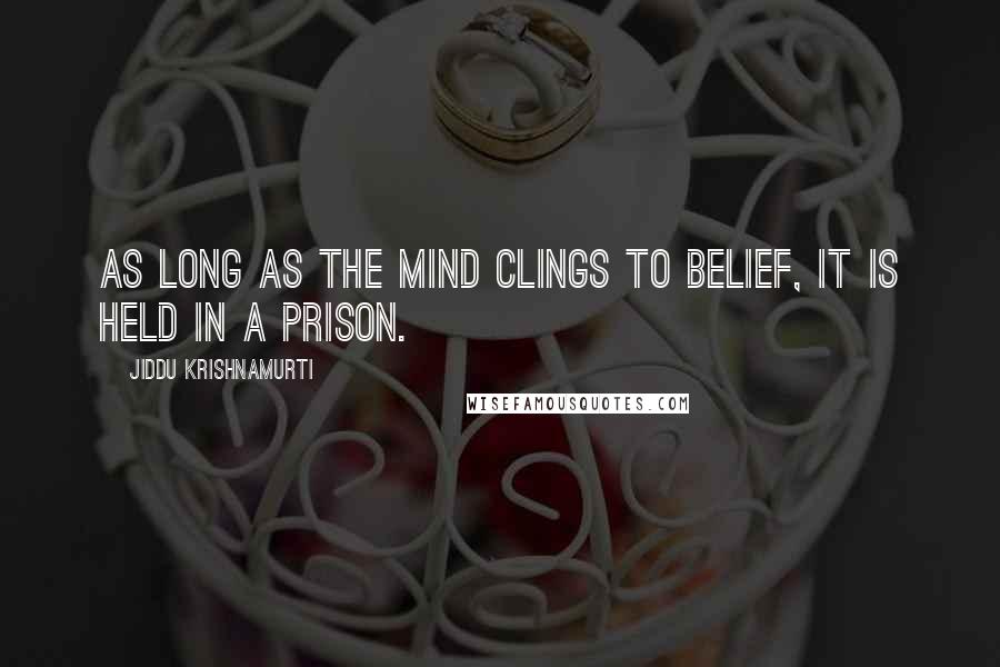 Jiddu Krishnamurti Quotes: As long as the mind clings to belief, it is held in a prison.