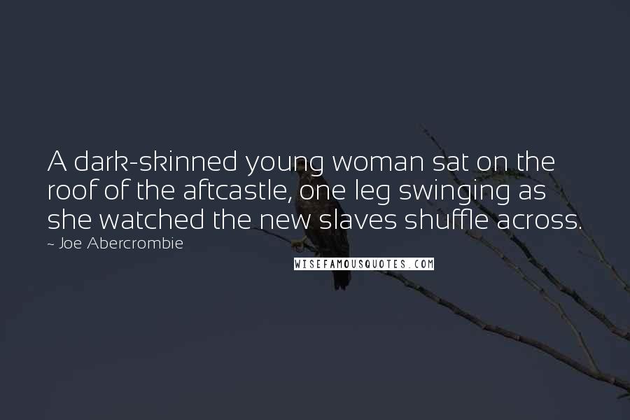 Joe Abercrombie Quotes: A dark-skinned young woman sat on the roof of the aftcastle, one leg swinging as she watched the new slaves shuffle across.