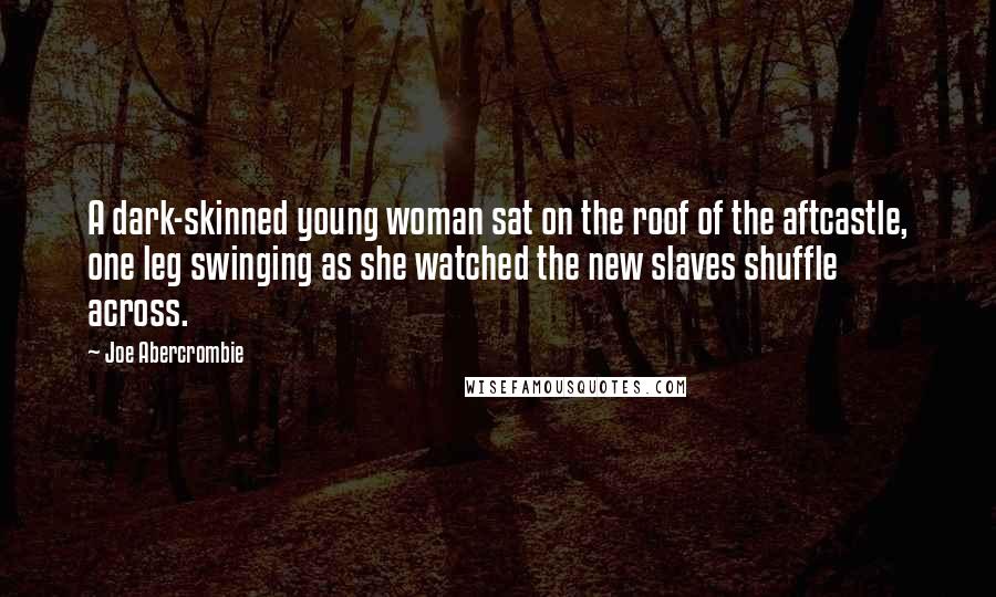 Joe Abercrombie Quotes: A dark-skinned young woman sat on the roof of the aftcastle, one leg swinging as she watched the new slaves shuffle across.
