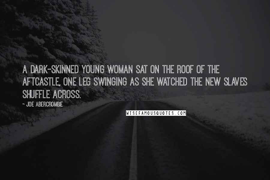 Joe Abercrombie Quotes: A dark-skinned young woman sat on the roof of the aftcastle, one leg swinging as she watched the new slaves shuffle across.