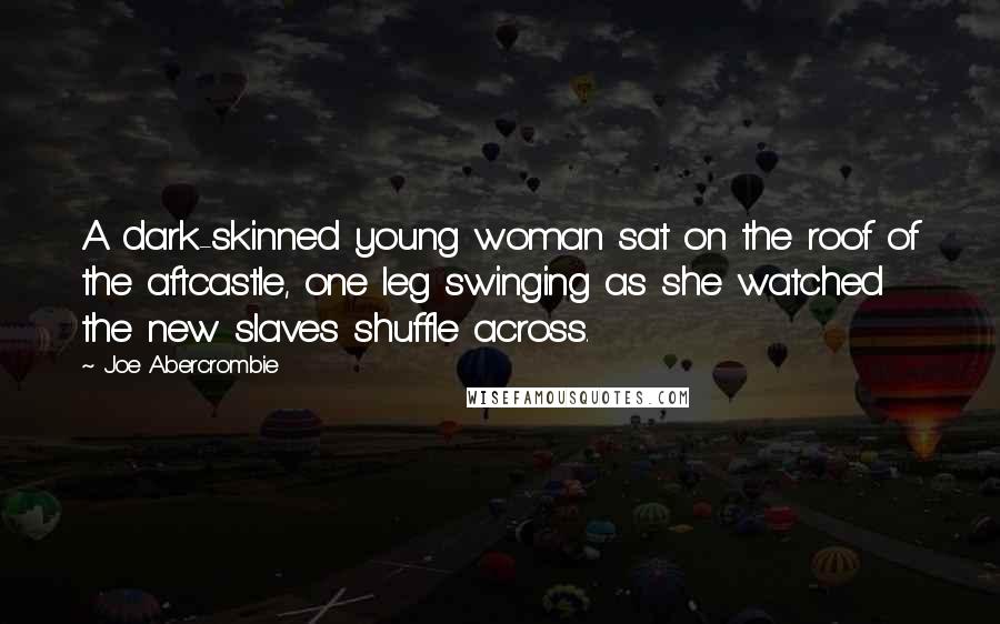 Joe Abercrombie Quotes: A dark-skinned young woman sat on the roof of the aftcastle, one leg swinging as she watched the new slaves shuffle across.