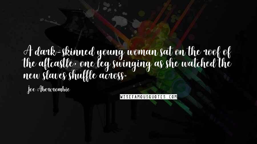 Joe Abercrombie Quotes: A dark-skinned young woman sat on the roof of the aftcastle, one leg swinging as she watched the new slaves shuffle across.