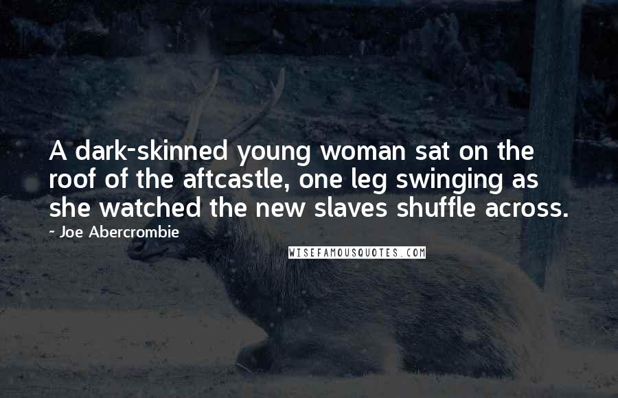 Joe Abercrombie Quotes: A dark-skinned young woman sat on the roof of the aftcastle, one leg swinging as she watched the new slaves shuffle across.