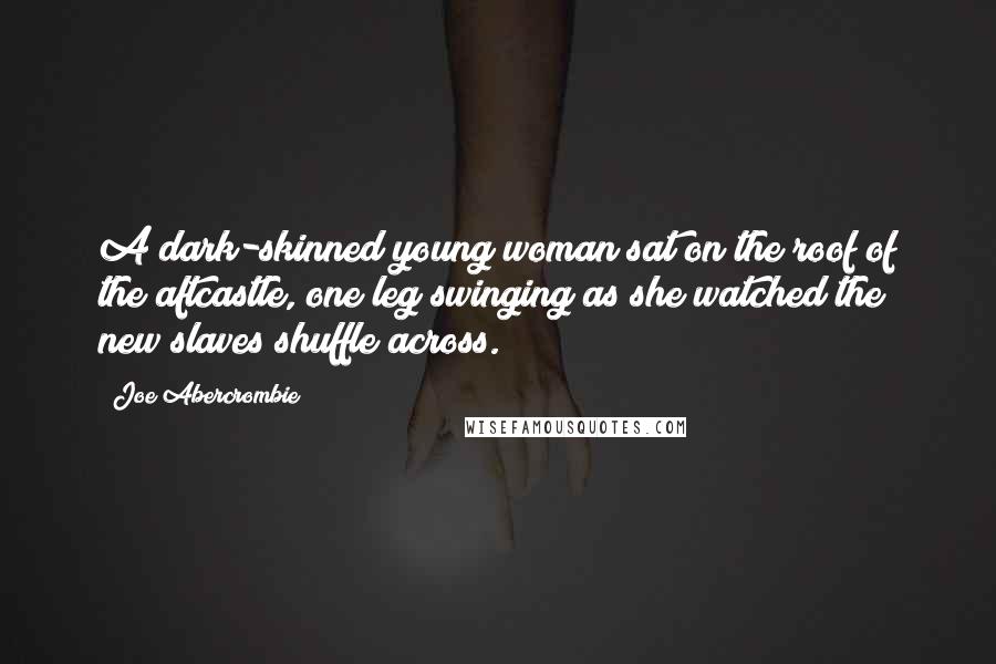 Joe Abercrombie Quotes: A dark-skinned young woman sat on the roof of the aftcastle, one leg swinging as she watched the new slaves shuffle across.