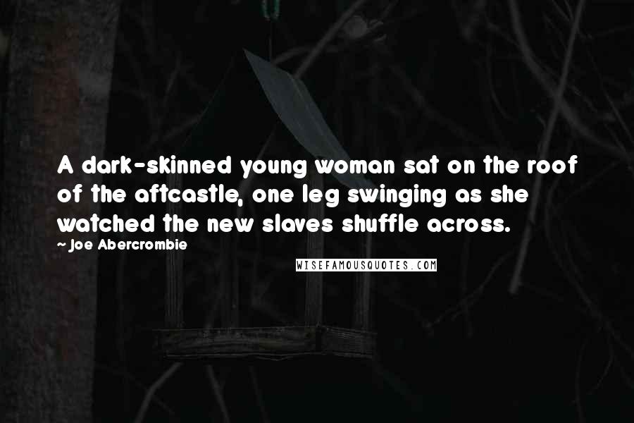 Joe Abercrombie Quotes: A dark-skinned young woman sat on the roof of the aftcastle, one leg swinging as she watched the new slaves shuffle across.