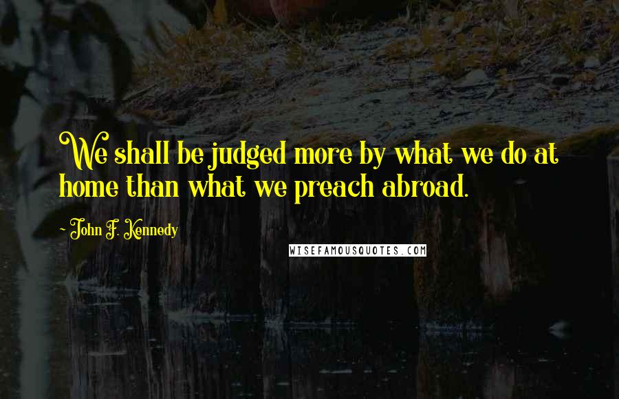 John F. Kennedy Quotes: We shall be judged more by what we do at home than what we preach abroad.