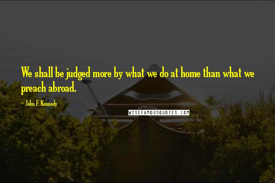 John F. Kennedy Quotes: We shall be judged more by what we do at home than what we preach abroad.