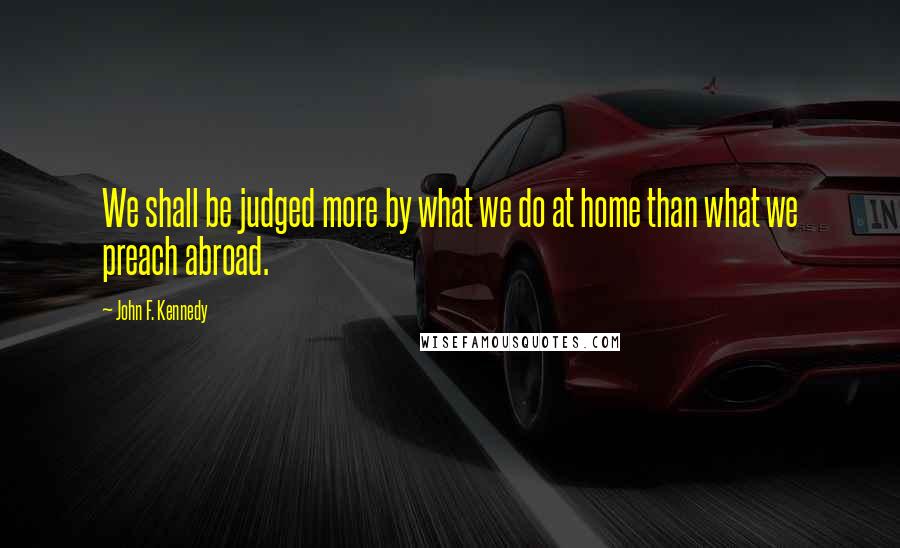 John F. Kennedy Quotes: We shall be judged more by what we do at home than what we preach abroad.