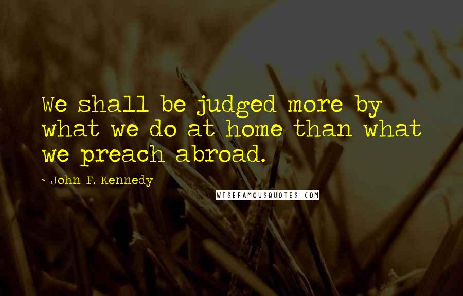 John F. Kennedy Quotes: We shall be judged more by what we do at home than what we preach abroad.