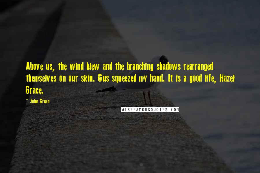 John Green Quotes: Above us, the wind blew and the branching shadows rearranged themselves on our skin. Gus squeezed my hand. It is a good life, Hazel Grace.