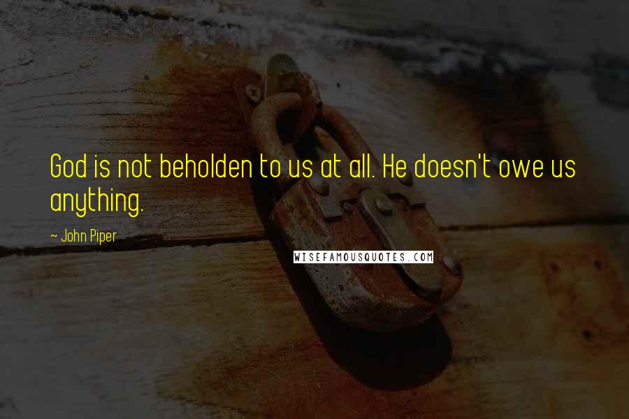 John Piper Quotes: God is not beholden to us at all. He doesn't owe us anything.