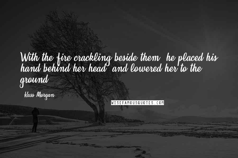 Kass Morgan Quotes: With the fire crackling beside them, he placed his hand behind her head, and lowered her to the ground.