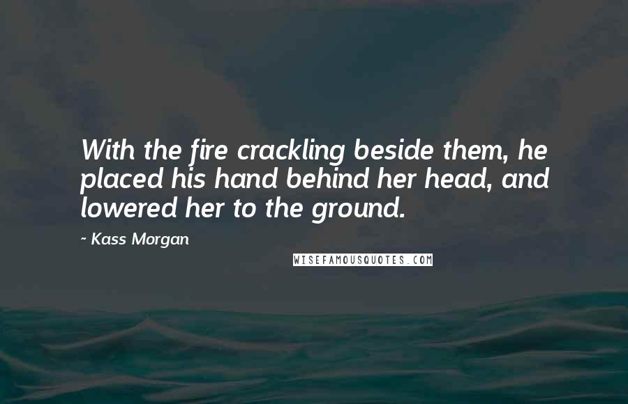 Kass Morgan Quotes: With the fire crackling beside them, he placed his hand behind her head, and lowered her to the ground.