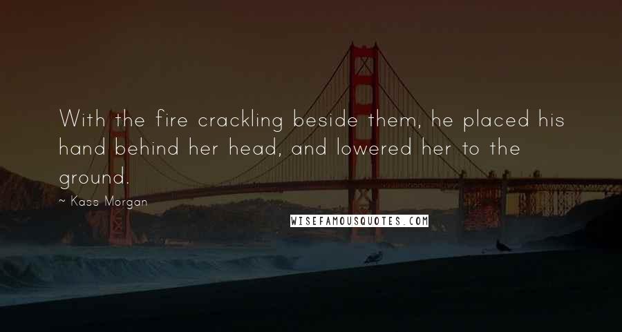 Kass Morgan Quotes: With the fire crackling beside them, he placed his hand behind her head, and lowered her to the ground.