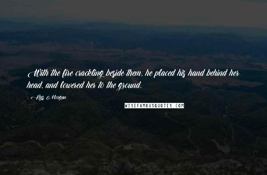 Kass Morgan Quotes: With the fire crackling beside them, he placed his hand behind her head, and lowered her to the ground.