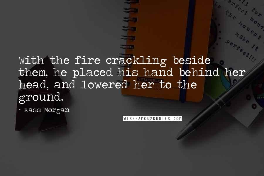 Kass Morgan Quotes: With the fire crackling beside them, he placed his hand behind her head, and lowered her to the ground.