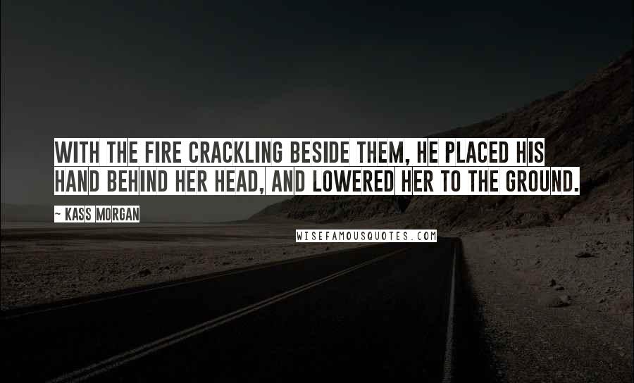 Kass Morgan Quotes: With the fire crackling beside them, he placed his hand behind her head, and lowered her to the ground.