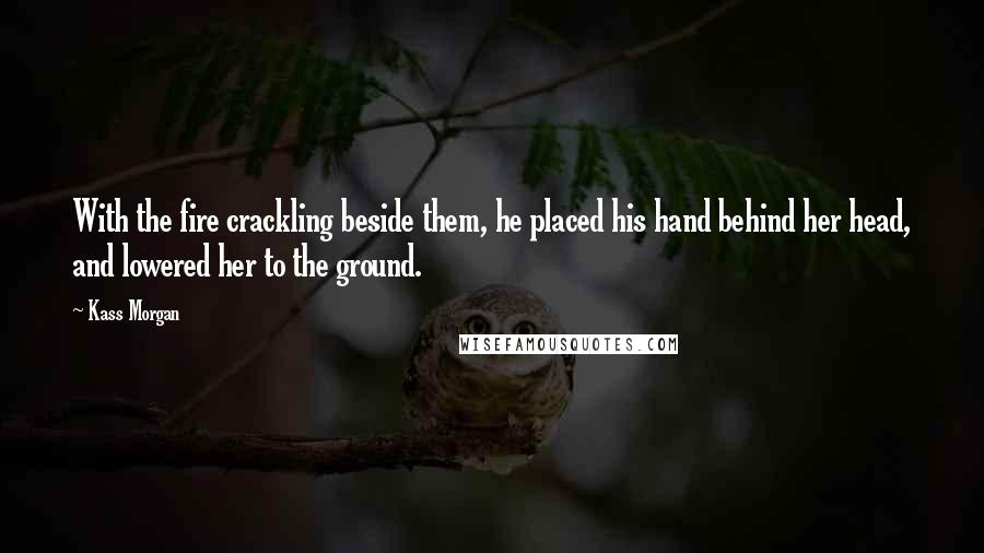 Kass Morgan Quotes: With the fire crackling beside them, he placed his hand behind her head, and lowered her to the ground.