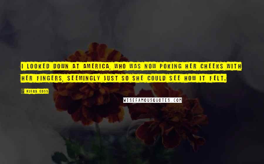 Kiera Cass Quotes: I looked down at America, who was now poking her cheeks with her fingers, seemingly just so she could see how it felt.