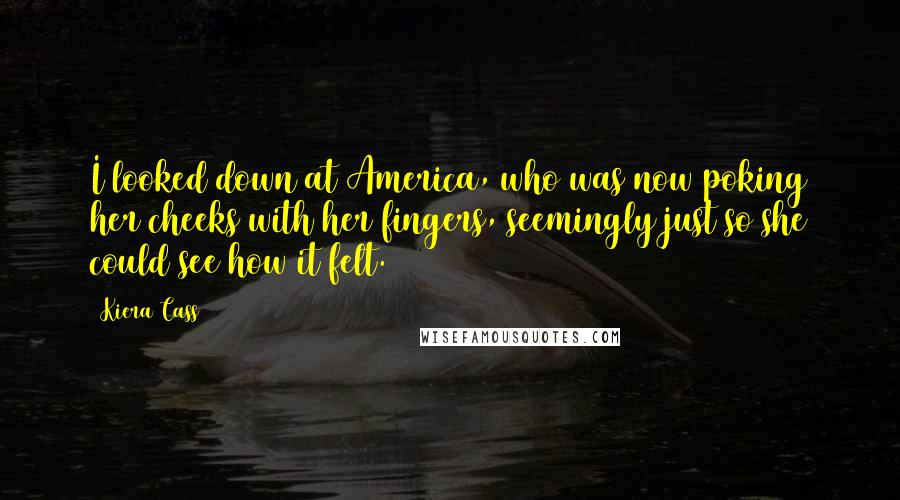 Kiera Cass Quotes: I looked down at America, who was now poking her cheeks with her fingers, seemingly just so she could see how it felt.