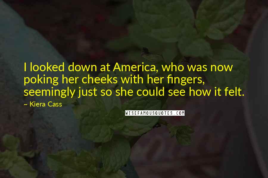 Kiera Cass Quotes: I looked down at America, who was now poking her cheeks with her fingers, seemingly just so she could see how it felt.