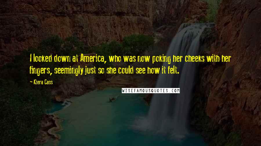 Kiera Cass Quotes: I looked down at America, who was now poking her cheeks with her fingers, seemingly just so she could see how it felt.