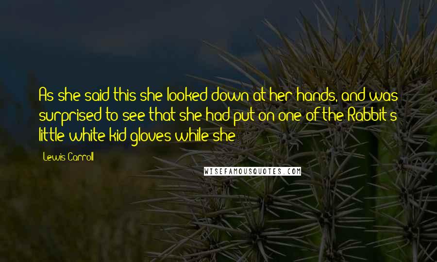 Lewis Carroll Quotes: As she said this she looked down at her hands, and was surprised to see that she had put on one of the Rabbit's little white kid gloves while she