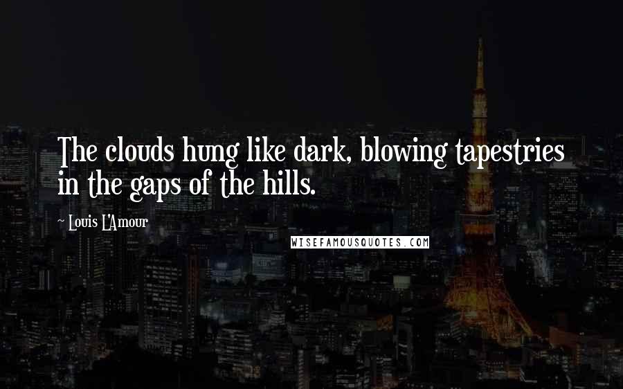 Louis L'Amour Quotes: The clouds hung like dark, blowing tapestries in the gaps of the hills.