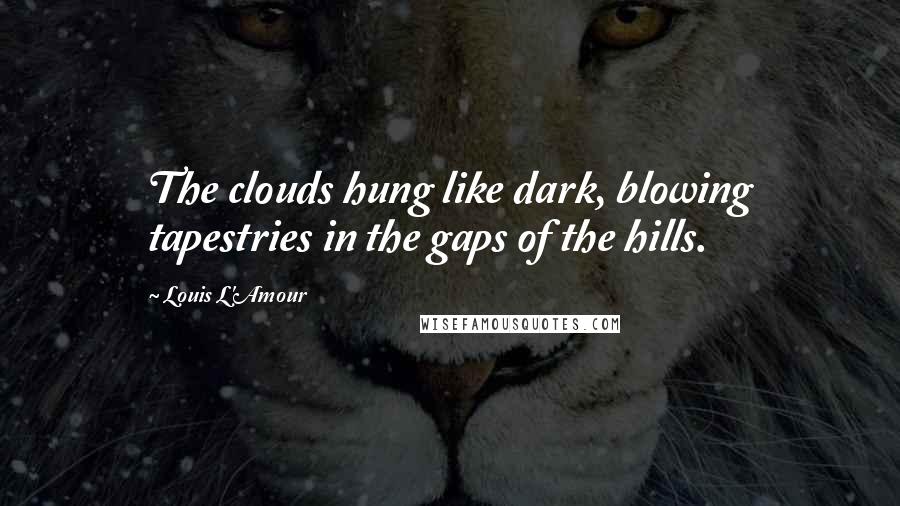 Louis L'Amour Quotes: The clouds hung like dark, blowing tapestries in the gaps of the hills.