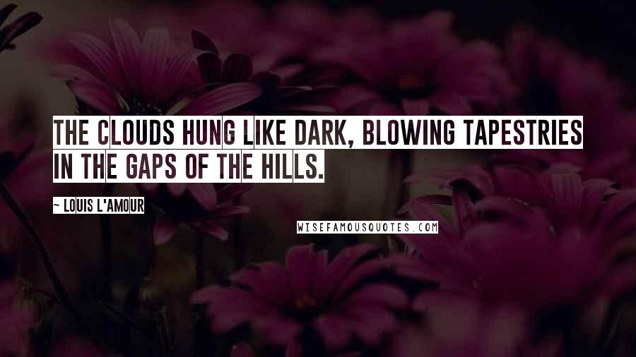Louis L'Amour Quotes: The clouds hung like dark, blowing tapestries in the gaps of the hills.