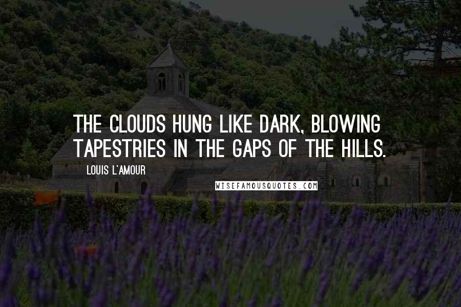 Louis L'Amour Quotes: The clouds hung like dark, blowing tapestries in the gaps of the hills.