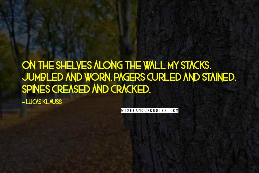 Lucas Klauss Quotes: On the shelves along the wall my stacks. Jumbled and worn. Pagers curled and stained. Spines creased and cracked.