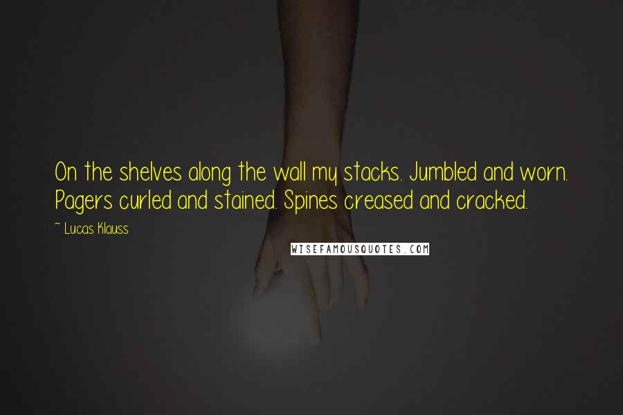 Lucas Klauss Quotes: On the shelves along the wall my stacks. Jumbled and worn. Pagers curled and stained. Spines creased and cracked.