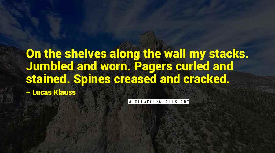 Lucas Klauss Quotes: On the shelves along the wall my stacks. Jumbled and worn. Pagers curled and stained. Spines creased and cracked.