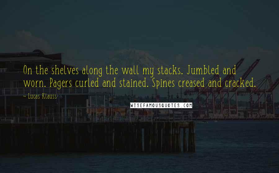 Lucas Klauss Quotes: On the shelves along the wall my stacks. Jumbled and worn. Pagers curled and stained. Spines creased and cracked.