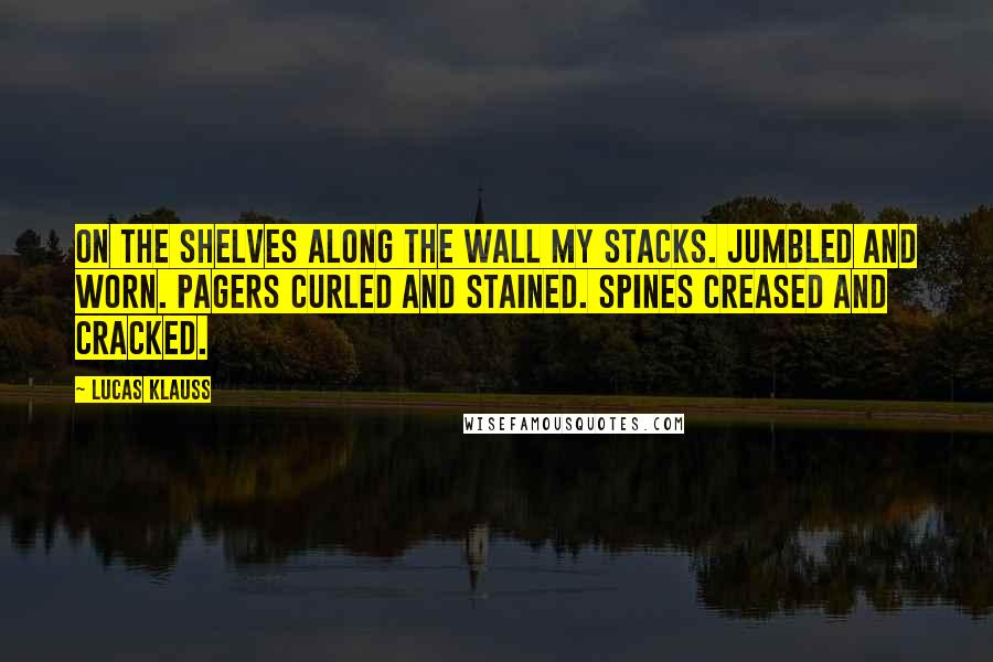 Lucas Klauss Quotes: On the shelves along the wall my stacks. Jumbled and worn. Pagers curled and stained. Spines creased and cracked.