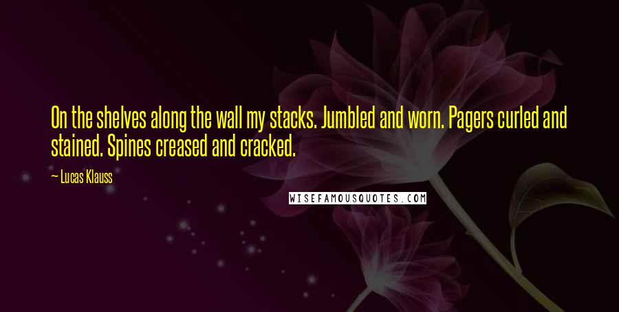 Lucas Klauss Quotes: On the shelves along the wall my stacks. Jumbled and worn. Pagers curled and stained. Spines creased and cracked.