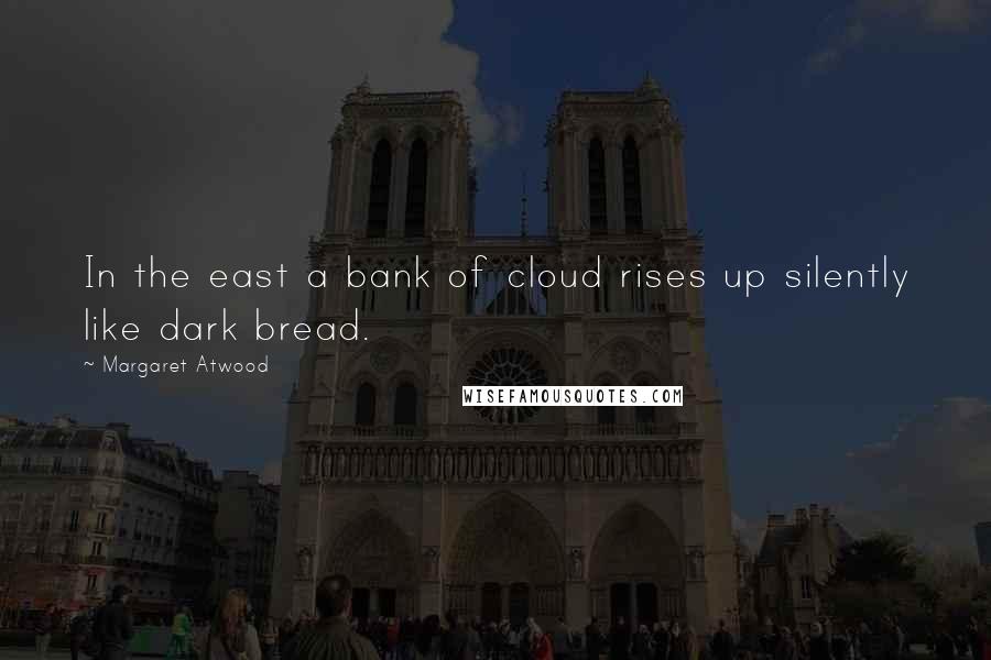 Margaret Atwood Quotes: In the east a bank of cloud rises up silently like dark bread.
